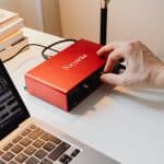 Rødt USB-lydkort tilsluttet en bærbar med et lydprogram åbent