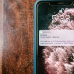 iPhone p&aring; et tr&aelig;bord med en falsk advarsel p&aring; l&aring;sesk&aelig;rmen