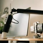 Podcastmikrofon på mikrofonarm over et skrivebord med skærm